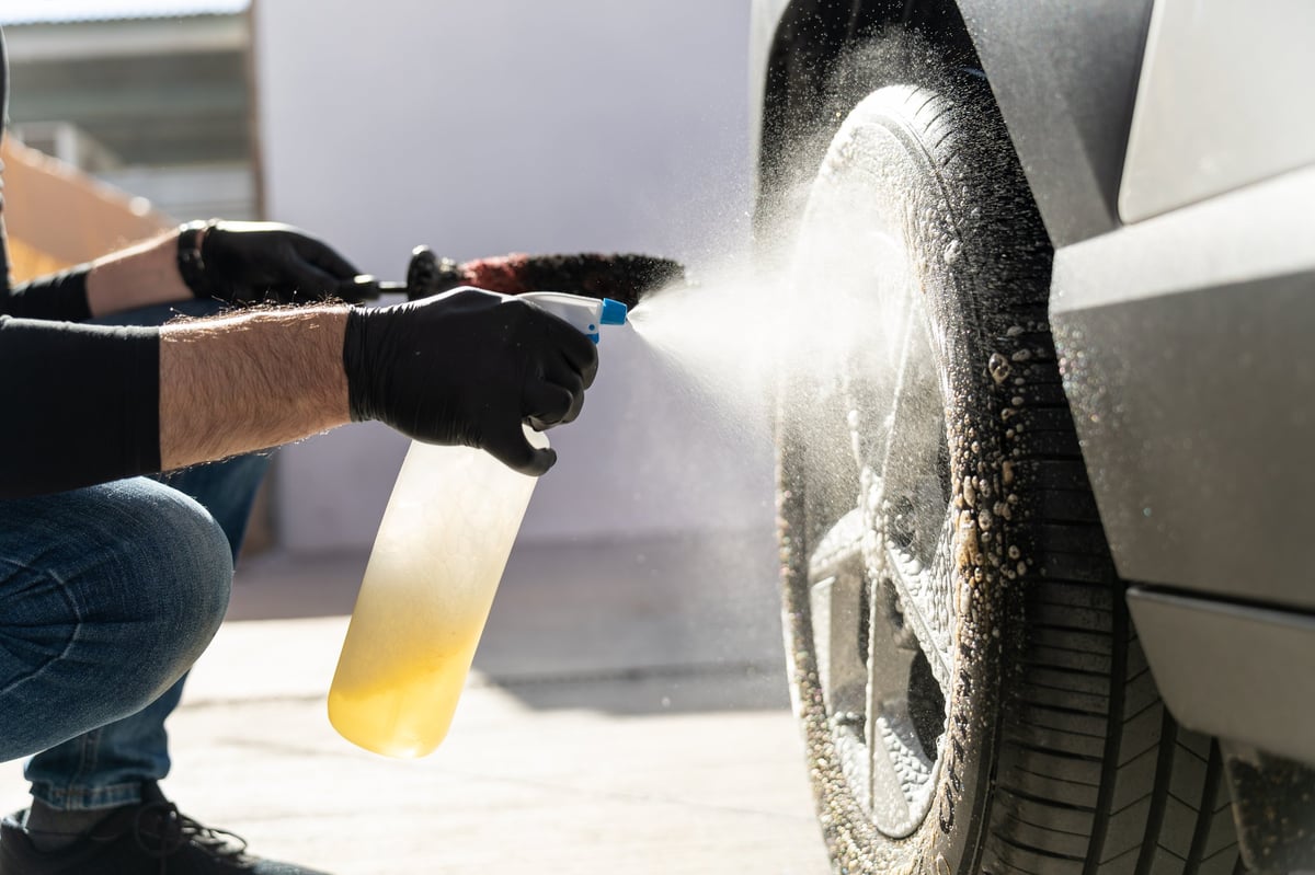 Professional cleaning a wheel and tire with cleaning solution